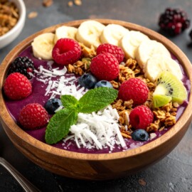 Açaí Bowl blends açaí puree with banana and mixed berries, topped with granola